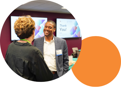 A man smiles at a woman during a networking event.