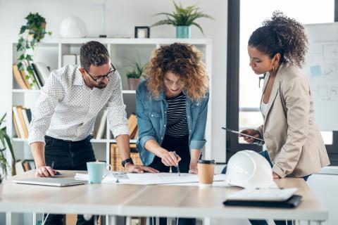 Three people around table planning